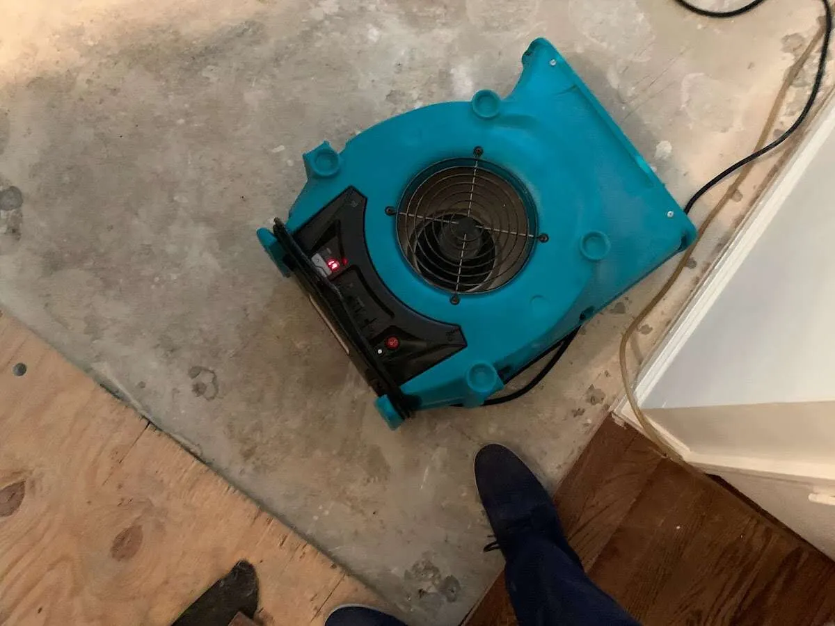 Air mover drying subfloor during Commercial Water Damage Restoration in White City